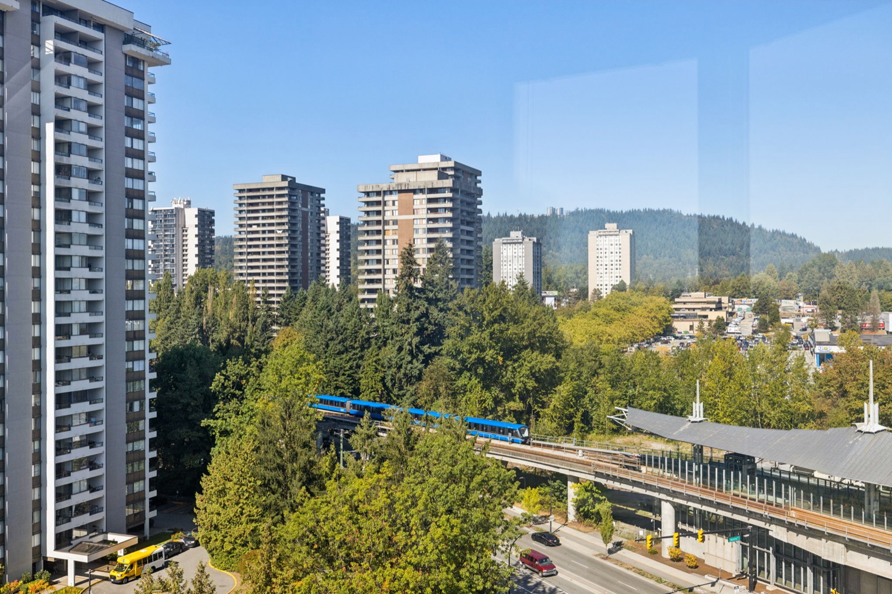 The SkyTrain passing below with the towers and mountains behind.