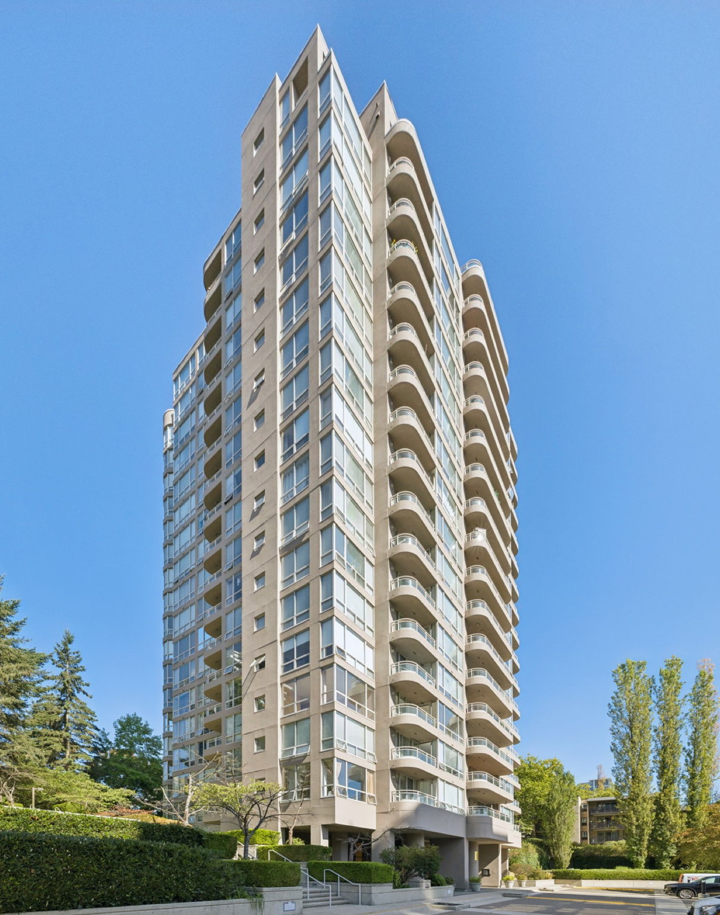 The tower seen from below, its curved balconies stacked against the sky.