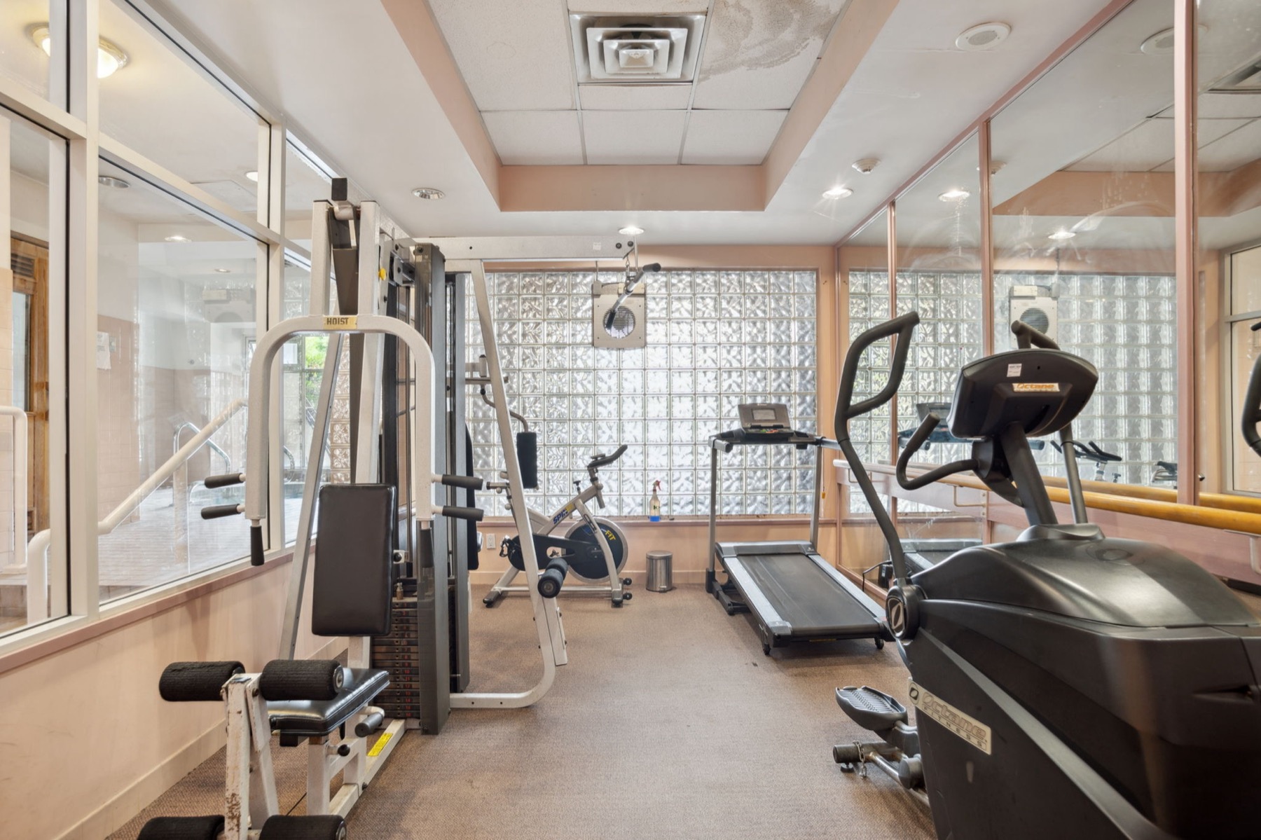 The exercise centre, machines beneath a glass-block wall.