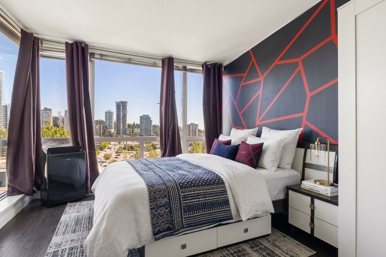 The primary bedroom, virtually staged: the bed beneath the corner glass, curtains drawn back to the city.