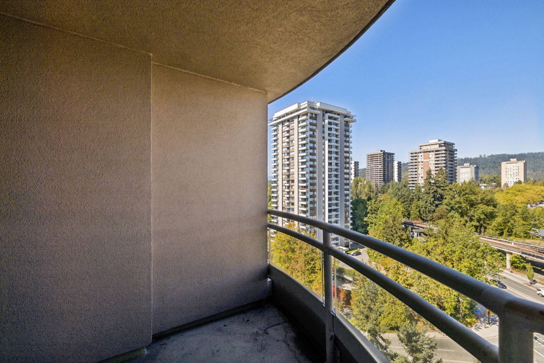 The balcony, its curved rail and the towers beyond.